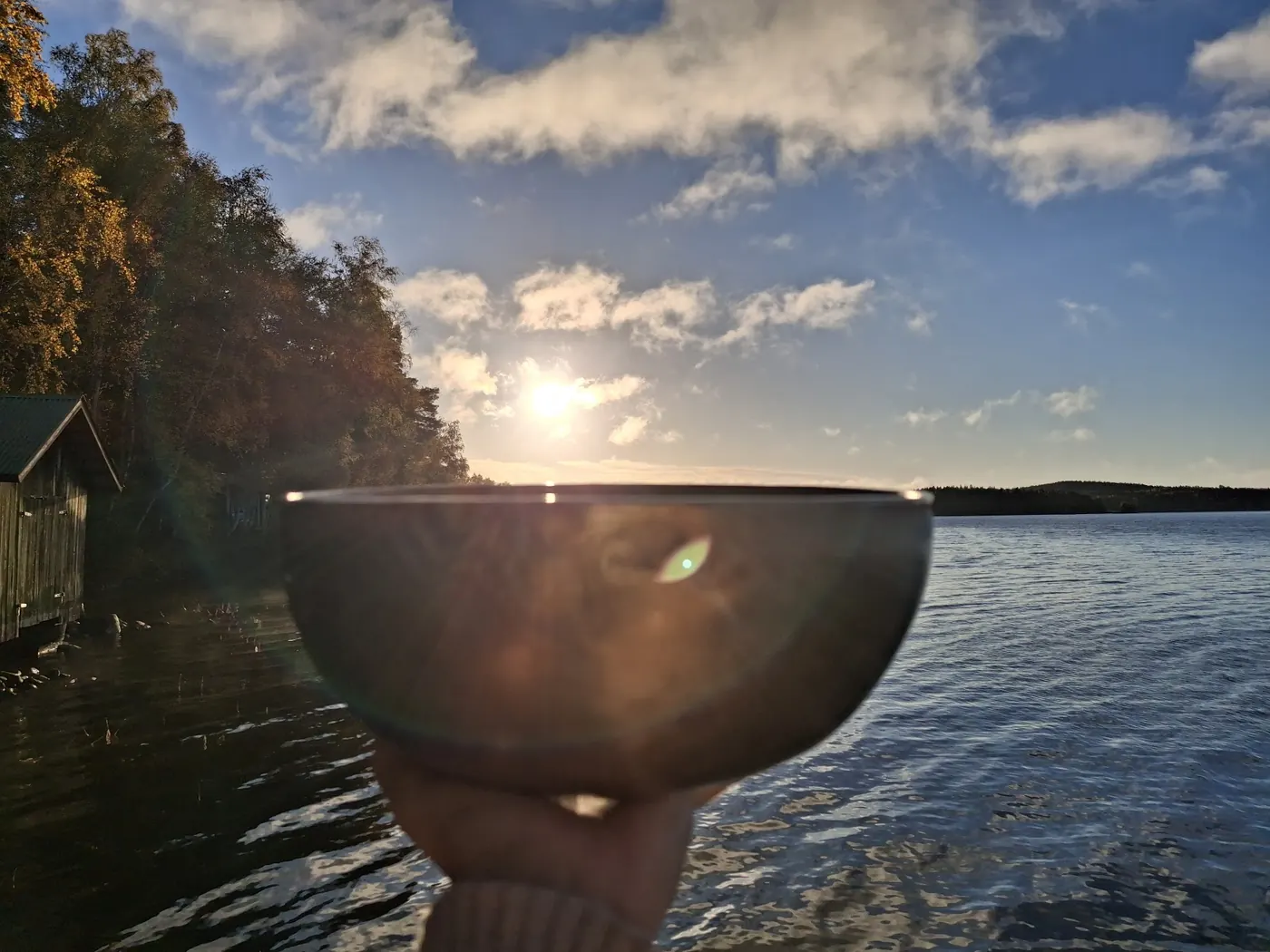 Äänimalja auringonnousussa järven rannalla