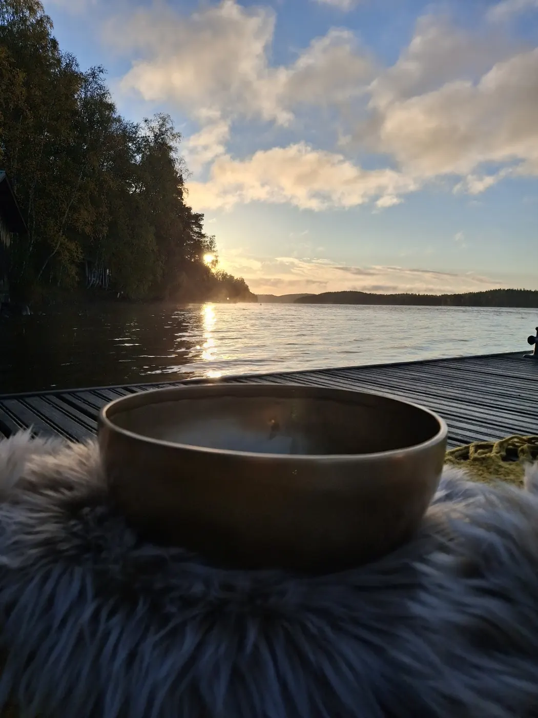 Suuri äänimalja taljan päällä laiturilla auringonlaskussa