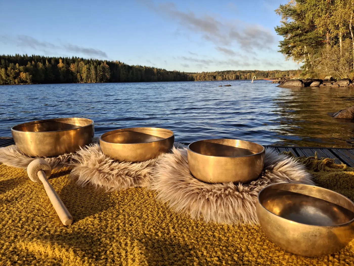 Äänimaljoja taljojen päällä järven rannalla aamuauringossa